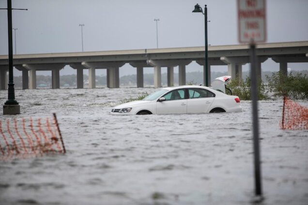 A car wades through flooded road in Louisiana