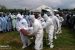Men in protective suits prepare to bury a COVID-19 dead