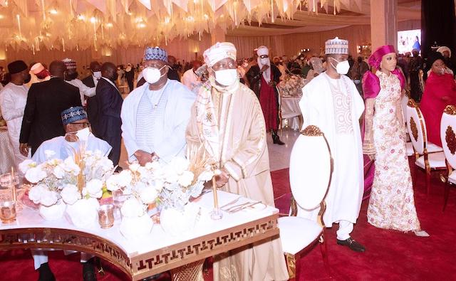 Buhari, sitting left,  watches as his son and his wife walk in