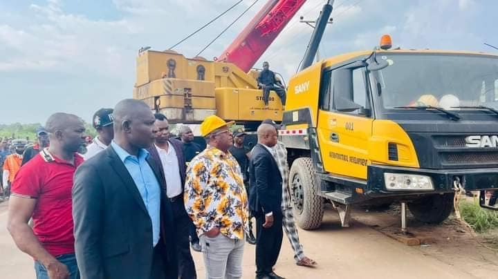 Governor Dave Umahi in yellow face cap with the crane to pull out bus in mining pit