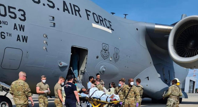 Medical support personnel from the 86th Medical Group help an Afghan mother and family off a U.S. Air Force C-17 just after she delivered a child aboard the aircraft. Photo: US Air Force