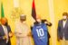 Infantino presents the striker's shirt to Buhari.Left is CAF President Dr. Patrice Motsepe. Right, Sports minister Sunday Dare