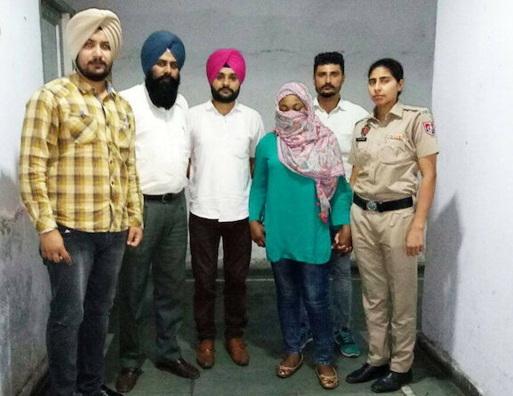 Joy Chika Ozuma in veil with Punjab police officials