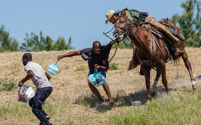 A United States Border Patrol agent on horseback tries to stop a Haitian migrant from entering an encampment. AFP Photo