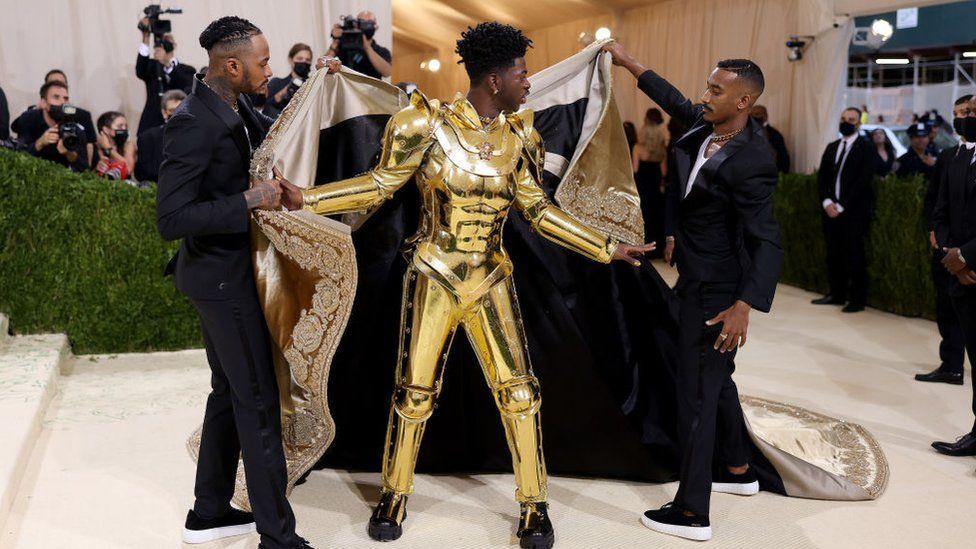 Lil Nas whipped off the robe to reveal a golden suit of Versace armour.