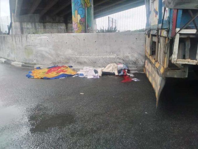 The remains of two boys of Madam Precious Sunday beside the truck that crushed them to death under the Isaac Boro Park flyover in Port Harcourt, Rivers State