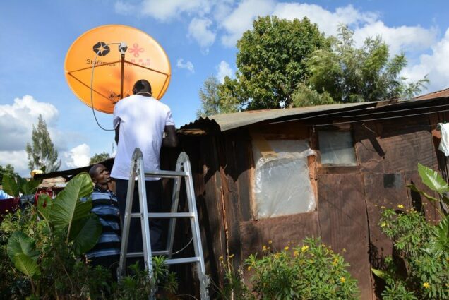 A satellite dish being installed in an Ugandan village