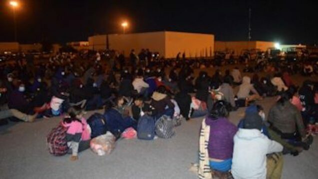 Arrested Migrants sit in a complex field of Public Security in Mexico