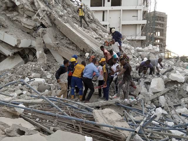 Emergency responders evacuating a dead body from the ruins