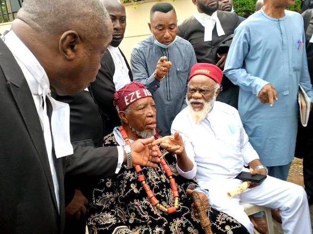 Ezeife and an Igbo monarch sit outside the court premises