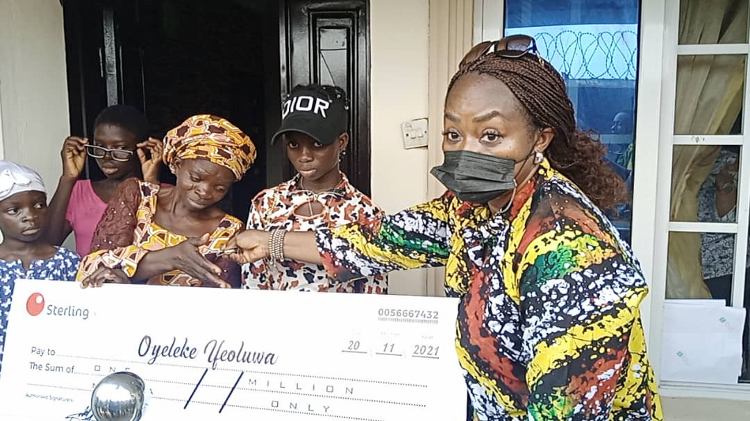Representative of Lagos State Governor, his Senior Special Assistant on Administration, Mrs. Titi Oshodi presenting a cheque of One million Naira gift and two bedroom apartment to Mrs. Ifeoluwa Oyeleke, mother of Jumoke who was killed during the Yoruba Nation Rally at Ojota, on Saturday