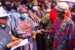 Governor Oyetola gives OHIS card to a beneficiary