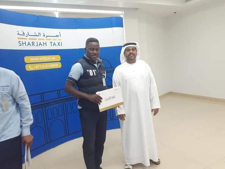 Abraham Airaodion receiving a certificate of appreciation from Sharjah Taxi