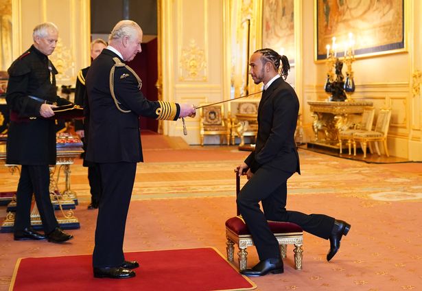 Sir Lewis Hamilton receiving his knighthood from Prince Charles