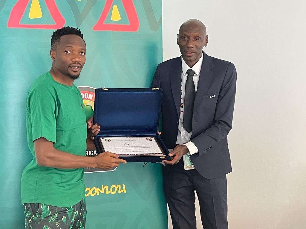 Captain Ahmed Musa (left) receives the certificate of welcome from CAF General Coordinator Titus Kunamuene.