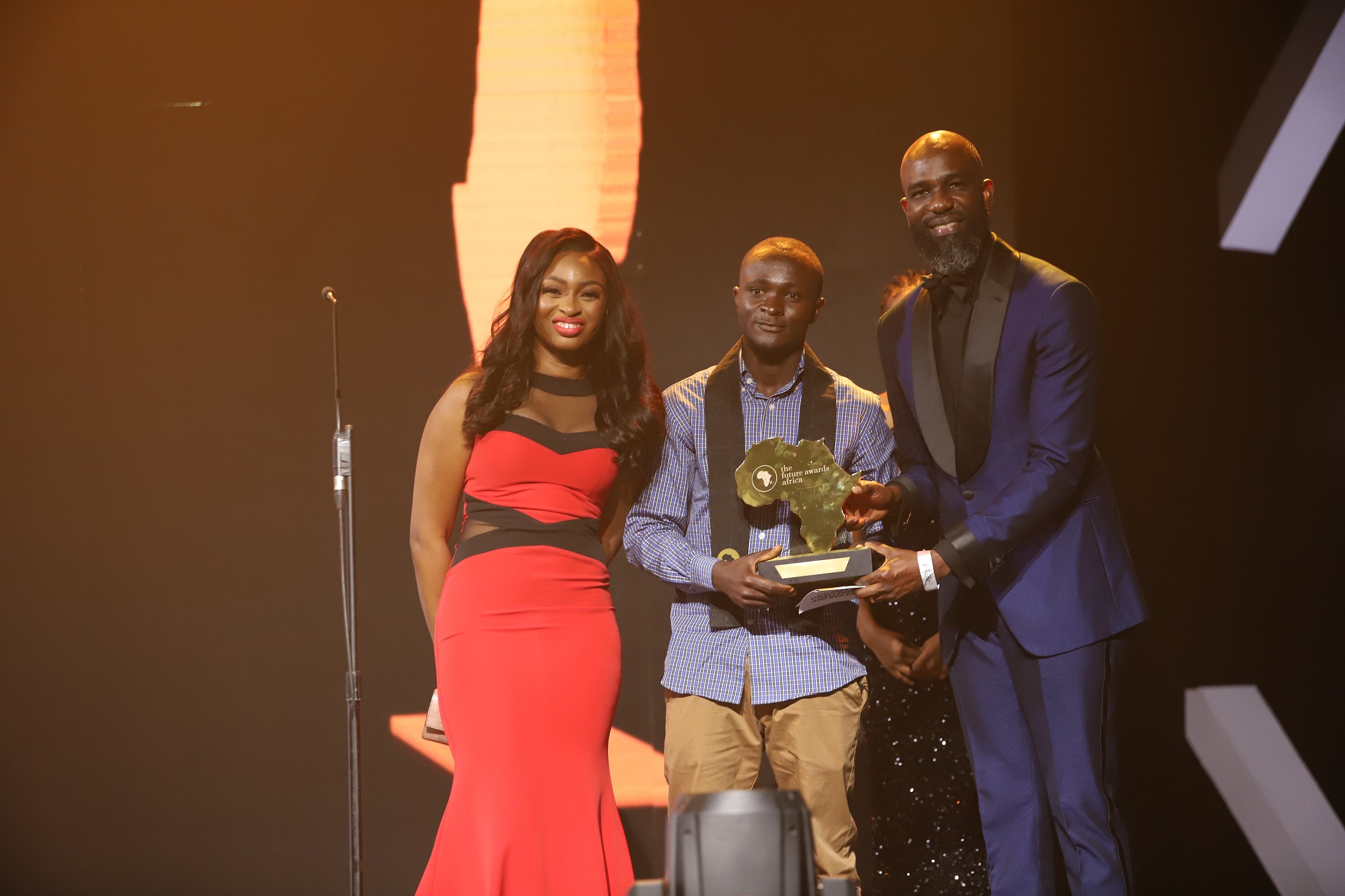 Dr Ola Brown (left) and Mai Atafo (right) presenting The Future Awards Africa Prize for Entrepreneurship to Jerry Mallo