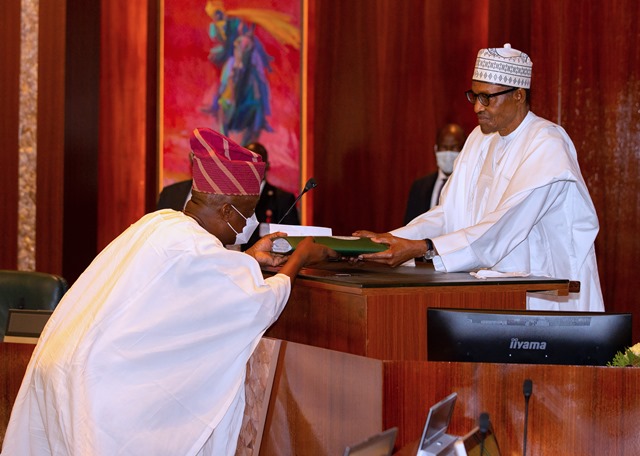 Buhari handing over the Electoral Act after signing it