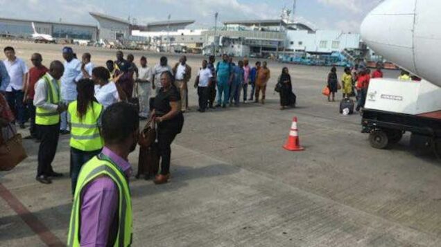 Passengers queue to board a flight in Lagos