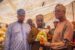 Prince Wole Oyebamiji hands over a gaari package to one of the vulnerables