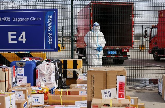 A staff stands behind baggage claim zone at Beijing Capital International Airport ahead of the Beijing 2022 Winter Olympics,