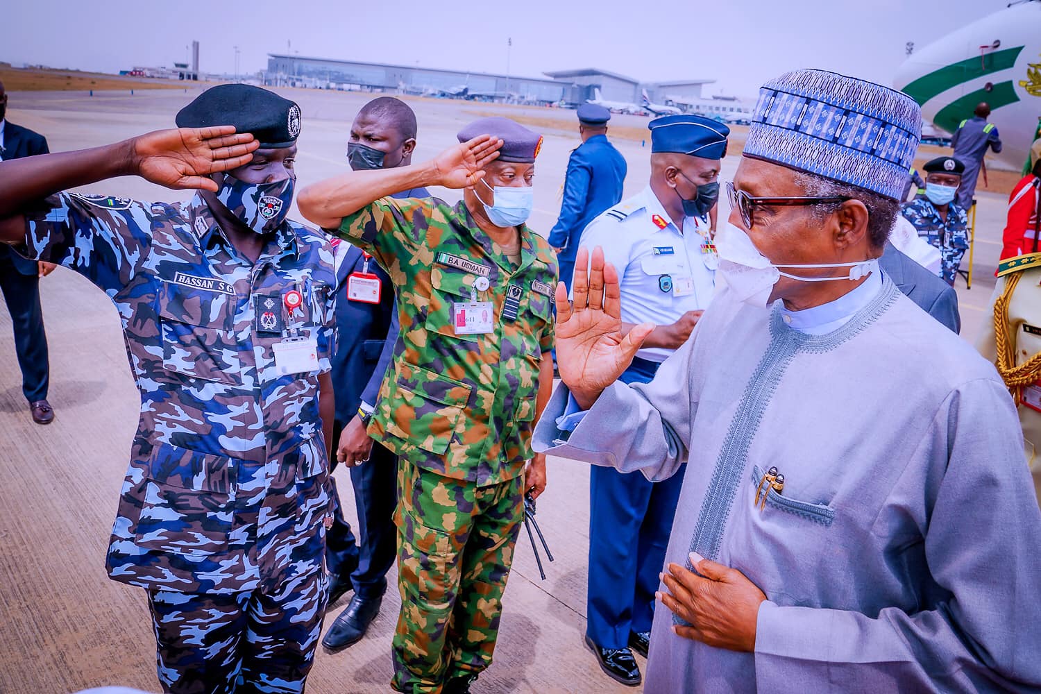 Buhari receives salute from security chiefs on arrival at the Abuja airport