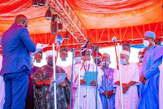Buhari, right watches as APC NWC members take the oath