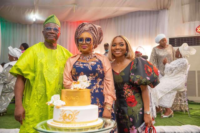 Toyin Machado-Onanuga cuts her birthday cake flanked by hubby, Bayo Onanuga and daughter Tobi