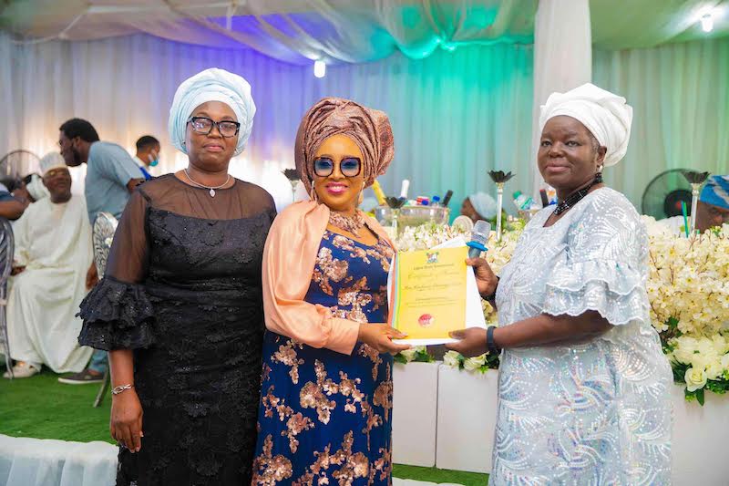 Toyin receives certificate of service from Mrs Olabisi Ariyo, chairman of TESCOM. Mrs Durodola, representative of the HOS Muri Okunola, left.