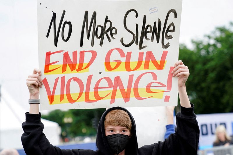 A demonstrator holds a placard while taking part in the 'March for Our Lives', one of a series of nationwide protests against gun violence, in Washington, D.C., U.S., June 11, 2022. REUTERS/Joshua Roberts/File Photo