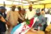 Chief Ogunleye, right gives teh APC flag to the PDP defectors
