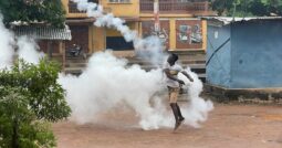 A protester in Freetown braves teargas