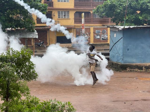 A protesters three a teargas canister at the police. Photo: Reuters
