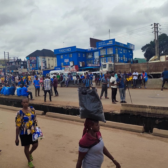 Traders at Uwelu International Spare parts market occupying the Benin-Lagos expressway, over deplorable condition of the road to the market