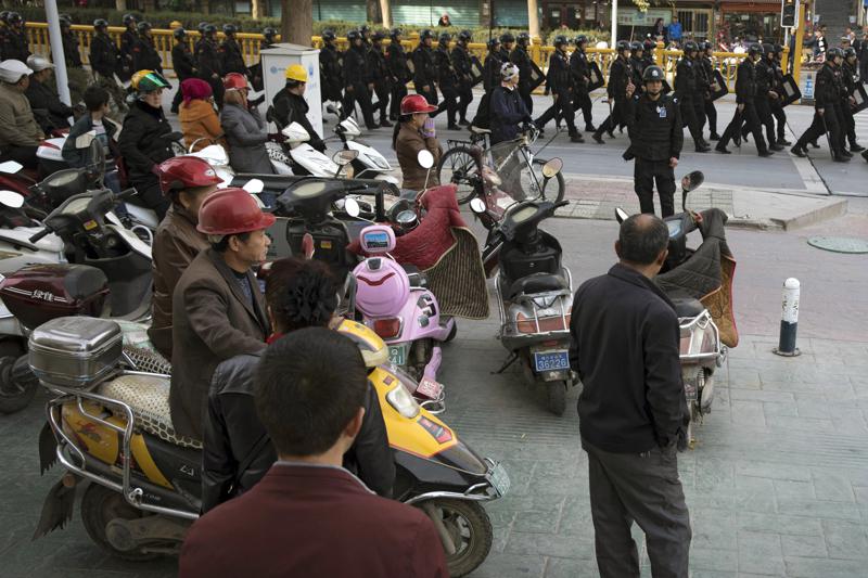 Chinese security personnel armed with batons and shields patrol through central Kashgar in western China's Xinjiang region,