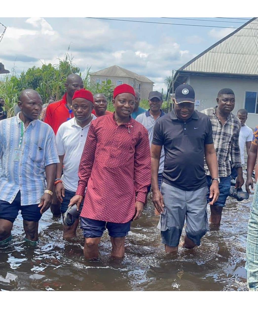 Goodluck Jonathan (in a black cap and polo shirt) visits flood victims.
