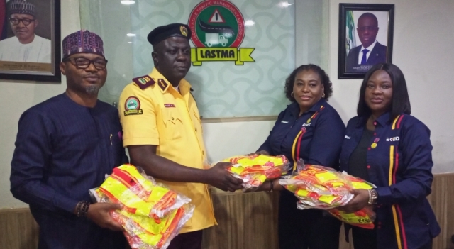 Mr. Oki Bakare receiving reflective jackets from EKEDC officials