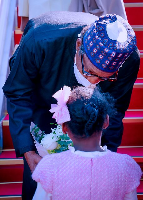 Buhari with a little child on arrival in Seoul