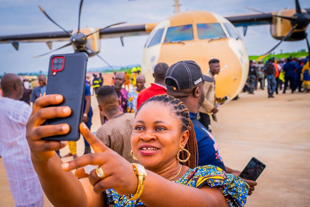 Excited citizens taking selfies with the first aircraft to land at Ekiti Airport