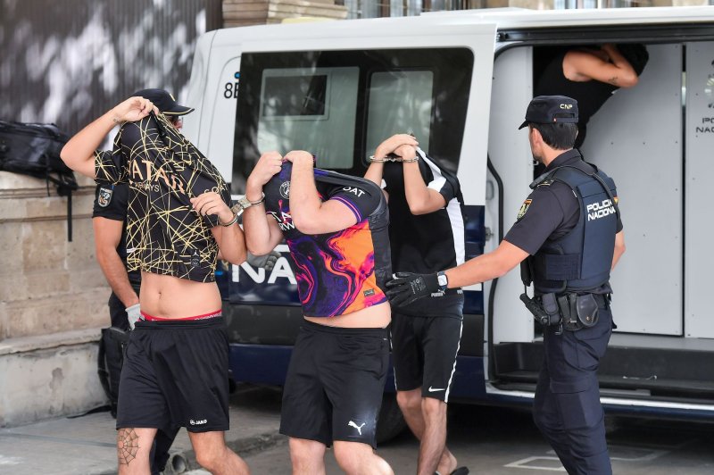 The three British men covering their faces as they went before a court in Palma, Spain
