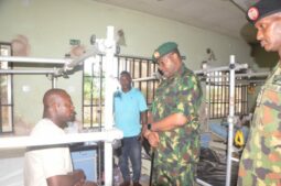 GOC Maj. General Hassan Dada, middle, with a wounded soldier in Owerri hospital