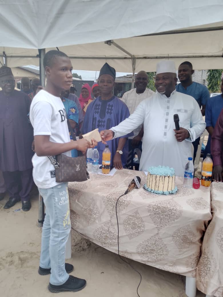 Oba-elect of Ijeododo area in Lagos Abu Ododo handing over cash gift to one of the youths who benefited from his skills acquisition initiatives and financial support.