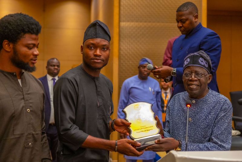 Tinubu, right with Nigerians in India