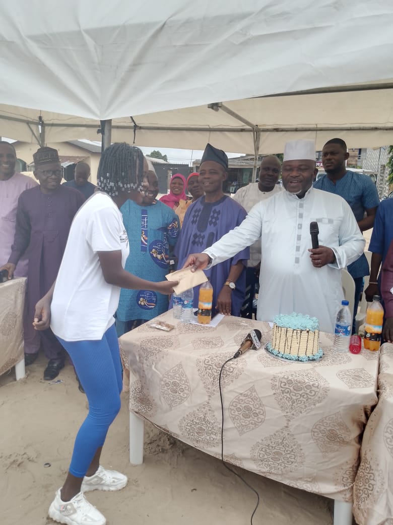 Oba-elect of Ijeododo area in Lagos Abu Ododo handing over cash gift to one of the youths who benefited from his skills acquisition initiatives and financial support.