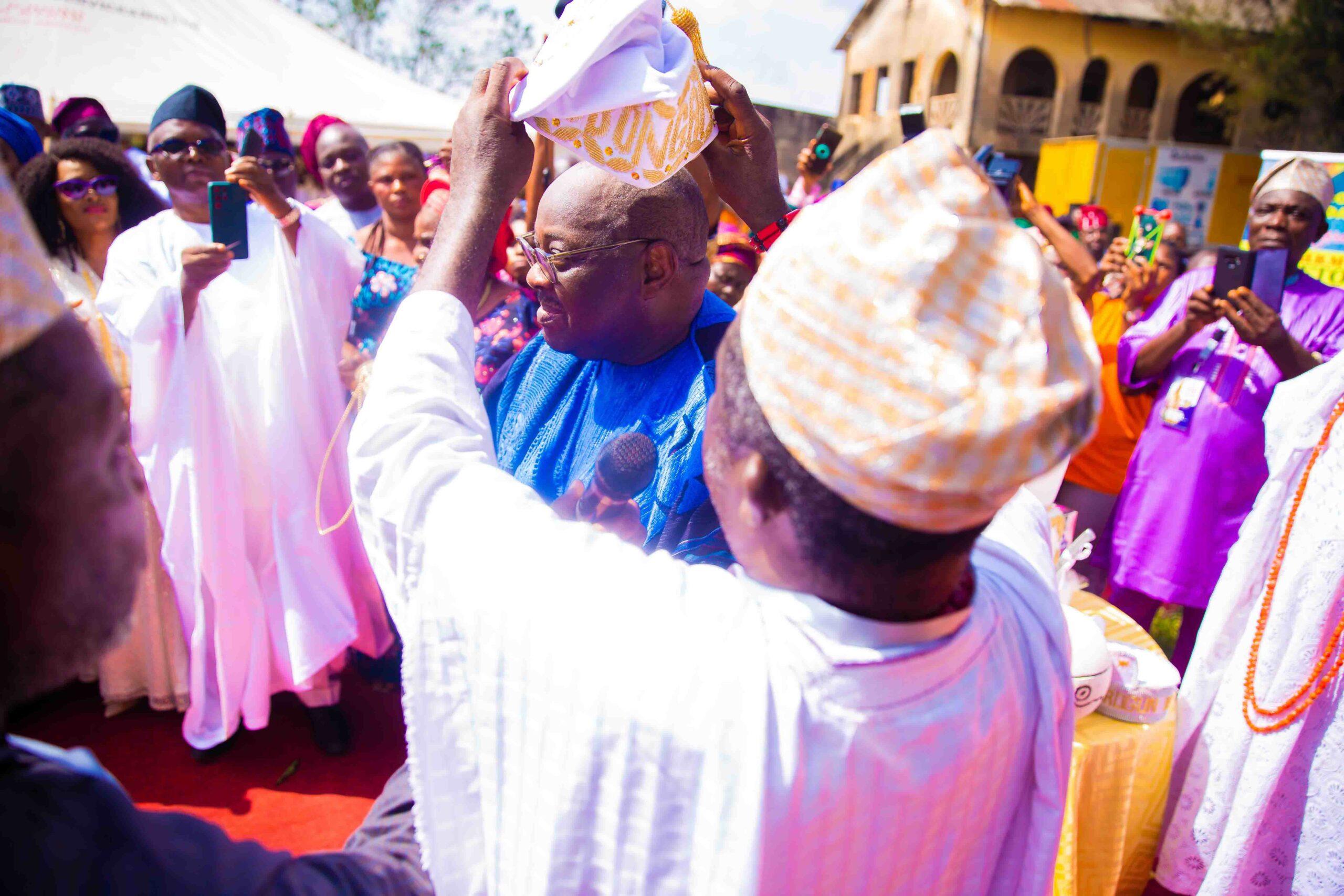 Chief Dele Momodu being installed as the Akinrogun of Gbonganland while Chief Mike Awoyinfa (in white 'Agbada') takes picture with his phone. (Photo credit: Ayodele Efunla)