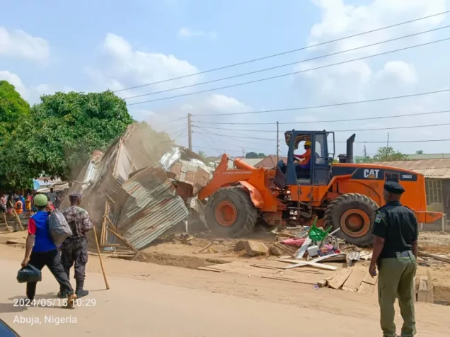 Caterpillar demolishing structures at Karmo market in Abuja on Wednesday