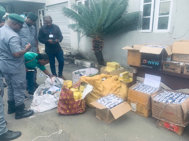 Comptroller of Customs, FOU Zone C, Owerri, Mr Michael Ugbuagu (Left) hand over of pharmaceutical contrabands intercepted by officers to Imo Coordinator of NAFDAC, Mrs Constance Ndukwe, (Second Left) on Friday in Owerri.