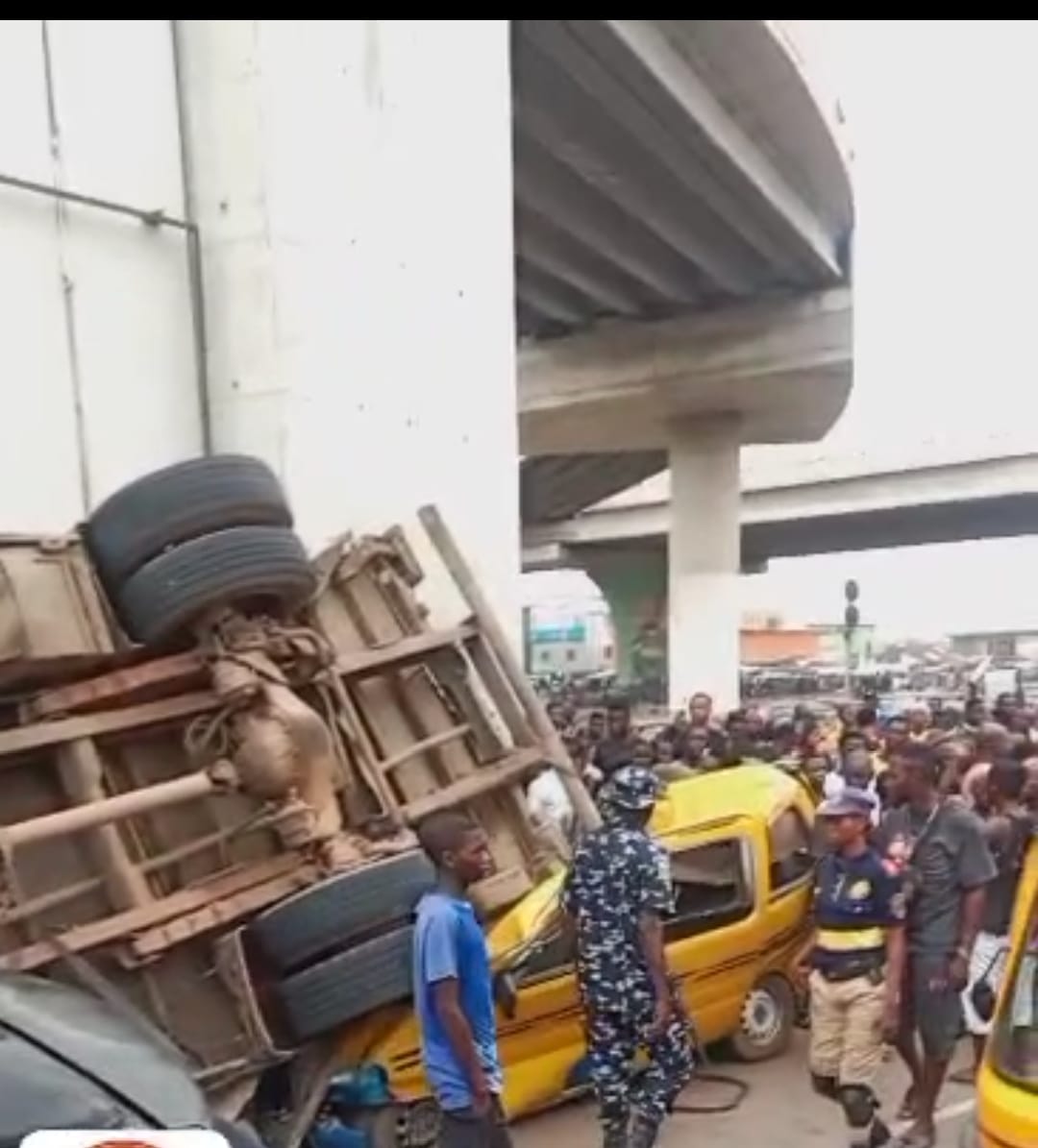 A driver was injured as his fully-laden truck plunged down Pen Cinema Bridge in Lagos and landed on two buses early Saturday morning.