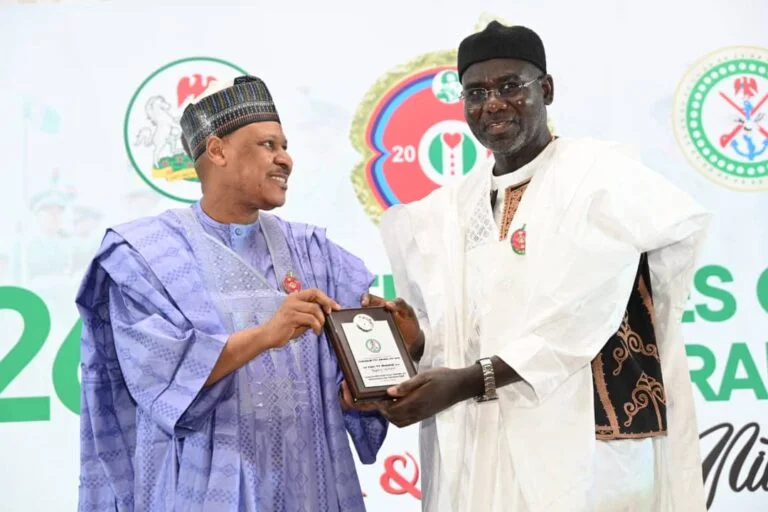 Retired Lt.-Gen. Tukur Buratai receiving his awards from the Minister of Information , Mohammed Idris